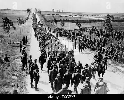 Official photograph taken on the British Western Front in France. German prisoners in batches of 1,000 arriving at a prisoners of war cage. Photograph shows a long line of German soldiers, prisoners of war, walking along roadway, somewhere in France. Stock Photo