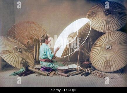 Hand coloured photograph of Kusakabe Kimbei, umbrella maker. Dated 1880 Stock Photo