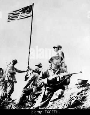 First flag set atop Mt. Suribachi, 23 February 1945, during World war Two United States Marine Corps photograph taken by Staff Sergeant Louis R. Lowery. Mount Suribachi is a 169 m high mountain at the southwest end of the island Iwo Jima. Stock Photo