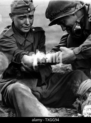 A captured, teenage, German soldier cries as he is treated for his ...