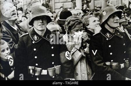 Photographic print of Austrian civilians standing behind an S.S. trooper during Germany Occupation of Austria, during the Second World War. Dated 20th Century Stock Photo