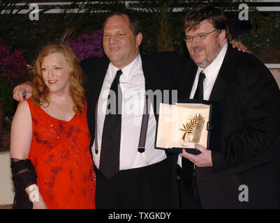 Director Michael Moore(right) poses with his wife Kathleen Glynn and Harvey Weinstein at a photocall after winning the Palme d'Or for his film 'Fahrenheit 911' at the Cannes Film Festival May 22, 2004 in Cannes, France. (UPI Photo/Christine Chew) Stock Photo