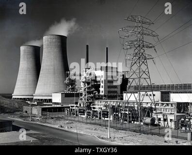 Calder Hall, Cumberland, England, the world's first full scale nuclear power station opened 17 October 1976.  On left are cooling towers and on right pylon carrying transmission lines distributing electricity to the National Grid. Photograph UK Atomic Energy Authority Stock Photo