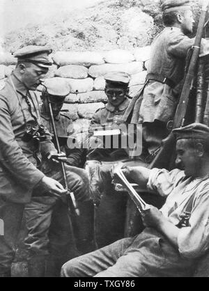 World War I, German soldiers reading, writing and smoking in the trenches during a lull in hostilities Stock Photo