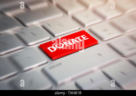 Red donate button on the keyboard close-up. blurred in motion background. Stock Photo