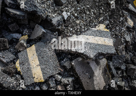 Broken asphalt road showing double yellow lines. Stock Photo