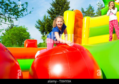 Happy little girls having lots of fun while jumping from ball to ball on an inflate house. Stock Photo