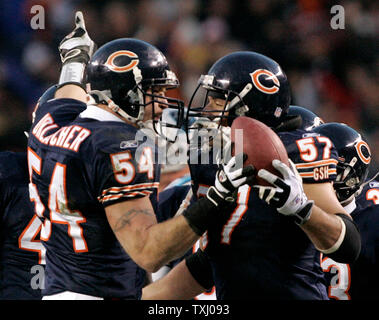 Chicago Bears linebacker Brian Urlacher (54) hands the ball to center Olin Kreutz (57) and points to the scoreboard after making an interception on a pass thrown by Carolina Panthers quarterback Jake Delhomme during the second quarter of NFC divisional playoff at Soldier Field in Chicago on January 15, 2006. The Panthers won 29-21. (UPI Photo/Brian Kersey) Stock Photo
