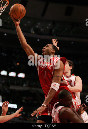 Houston Rockets' Tracy McGrady (1) charges over Chicago Bulls' Luol Deng, right, of Sudan as he goes up for a layup during the fourth quarter on January 20, 2006, in Chicago. McGrady was called for an offensive foul. The Rockets won 109-108 in double overtime. (UPI Photo/Brian Kersey) Stock Photo