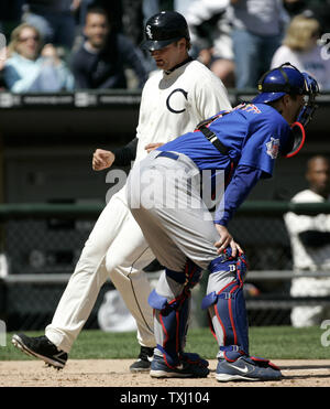 Chicago White Sox's A.J. Pierzynski, back, scores on Rob Mackowiak's double as Chicago Cubs catcher Michael Barrett waits for the throw from the outfield during the seventh inning at U.S. Cellular Field in Chicago, on May 21, 2006. The Cubs won 7-4. (UPI Photo/Brian Kersey) Stock Photo