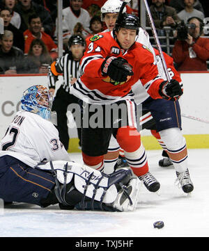 Edmonton Oilers Goaltender Mathieu Garon L Trips Up Chicago Blackhawks Adam Burish As He Goes For The Puck During The Second Period In Chicago On March 9 2008 The Oilers Won 6 5