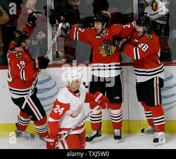 Chicago Blackhawks Jonathan Toews (19), Adam Burish (C) and Patrick Kane (88) celebrate Burish's goal as Detroit Red Wings' Chris Chelios (24) skates by during the third period in Chicago on April 2, 2008. The Blackhawks won 6-2. (UPI Photo/Brian Kersey) Stock Photo