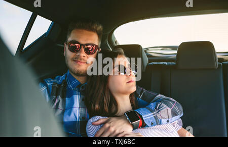 Young couple resting in the backseat of the car Stock Photo