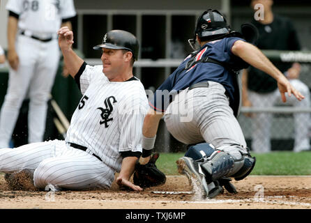 Chicago White Sox's Jim Thome (L) scores past  Minnesota Twins catcher Joe Mauer after Jermaine Dye hit a single during the second inning in Chicago on June 9, 2008. (UPI Photo/Brian Kersey) Stock Photo