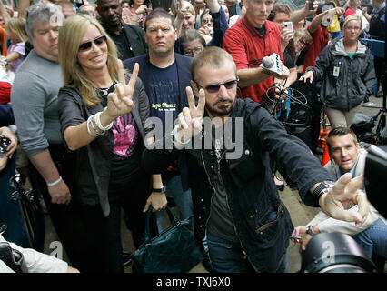 Former Beatle Ringo Starr (R) and his wife Barbara Bach greet fans with the peace sign in celebration of his 68th birthday in Chicago on July 7, 2008. Starr asked his fans around the world to show the peace sign at noon local time in honor of his birthday. (UPI Photo/Brian Kersey) Stock Photo