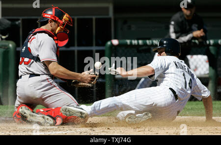 Chicago White Sox's Paul Konerko (R) scores as Boston Red Sox catcher Jason Varitek drops the throw from third baseman Mike Lowell after Juan Uribe hit a ground ball during the fifth inning on August 10, 2008 in Chicago. (UPI Photo/Brian Kersey) Stock Photo