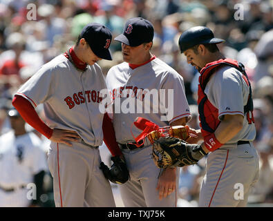 Boston Red Sox pitching coach John Farrell (C) and catcher Jason Varitek (R) talks with pitcher Clay Buchholz during the second inning against the Chicago White Sox on August 10, 2008 in Chicago. The White Sox won 6-5. (UPI Photo/Brian Kersey) Stock Photo