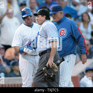 Chicago Cubs manager Lou Piniella (R) holds back Jim Edmonds (L) as he  argues with home plate umpire Ed Rapuano (C) after Rapuano ejected Edmonds  for arguing ball and strikes during the 11th inning against the against the  Milwaukee Brewers at