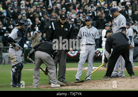 Chicago White Sox grounds crew work on the mound as Tampa Bay Rays catcher Dioner Navarro (L) home plate umpire Ron Kulpa shortstop Jason Bartlett and pitcher Matt Garza watch during the fifth inning of game 3 of the 2008 American League Division Series at U.S. Cellular Field in Chicago, on October 4, 2008. The White Sox won 5-3 to force a game 4 and trail in the best of five series 1-2 games. (UPI Photo/Brian Kersey) Stock Photo