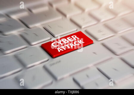 Close-up view on conceptual keyboard - Cyber Attack red key on grey silver laptop keyboard. blurred in motion background. Stock Photo