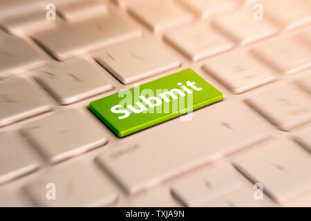 Submit Button. Keyboard Concept. Green Button on grey Computer Keyboard. blurred in motion background. Stock Photo