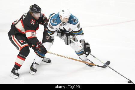 Chicago Blackhawks defenseman Brent Sopel (L) tries to steal the puck from San Jose Sharks left wing Ryane Clowe during the second period at the United Center in Chicago on December 22, 2009. The Sharks won 3-2.     UPI/Brian Kersey Stock Photo