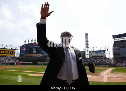 Former Chicago White Sox first baseman and designated hitter Frank Thomas  holds his son Frank, 15 months, as he waves to fans during a ceremony  retiring his number before the game against