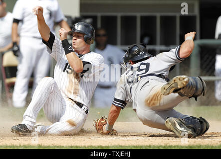 Chicago White Sox's Gordon Beckham (L) scores past New York Yankees catcher Francisco Cervelli on an RBI single hit by Juan Pierre during the fifth inning at U.S. Cellular Field in Chicago on August 29, 2010.     UPI/Brian Kersey Stock Photo
