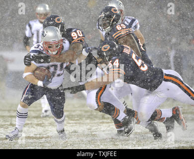 Chicago Bears defensive end Julius Peppers (C) and linebacker Brian  Urlacher tackle New England Patriots running back Danny Woodhead after he  gained 5-yards on a short pass during the second quarter at