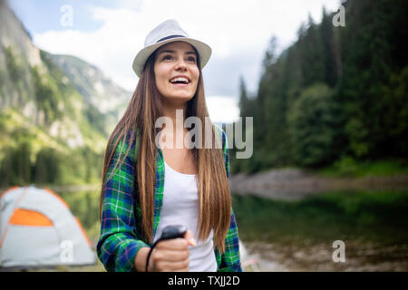 Young woman traveling with backpack hiking in mountains Stock Photo