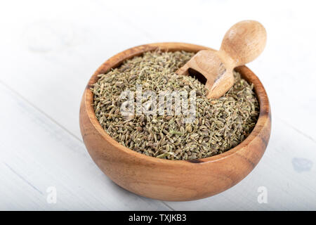 Dried fennel seeds in the wooden bowl on wooden background. Stock Photo