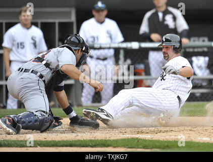 Chicago White Sox's Paul Konerko (R) scores past Detroit Tigers catcher Alex Avila on a RBI triple hit by A. J. Pierzynski during the sixth inning at U.S. Cellular Field on April 13, 2012 in Chicago.    UPI/Brian Kersey Stock Photo