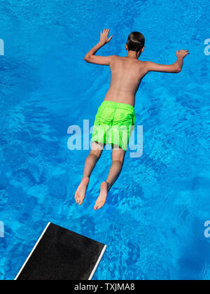 25 June 2019, Lower Saxony, Göttingen: A visitor to the outdoor pool at Brauweg jumps from the 3-metre tower into a pool. Photo: Swen Pförtner/dpa Stock Photo