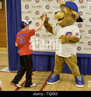 The Chicago Cubs mascot high fives a Hanshin Tigers cheerleader during ...