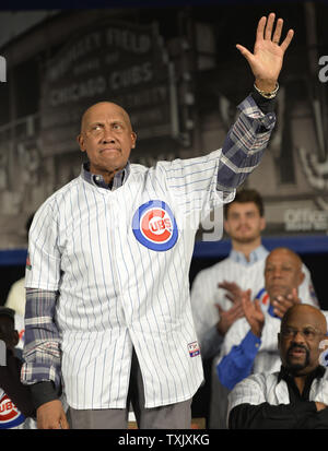 Former Chicago Cubs pitcher Ferguson Jenkins (R) shakes hands with Ryan  Theriot after Jenkins and Greg Maddux's number 31 was retired in a ceremony  before the game against the Florida Marlins at