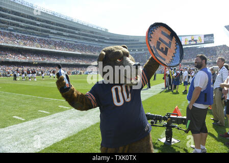 Illinois Army National Guard 2nd Lt. Zachary White, of Chicago, takes a  photo with Staley Da Bear, the Chicago Bears mascot during the Chicago Bears  Salute to Service game Nov. 27 at