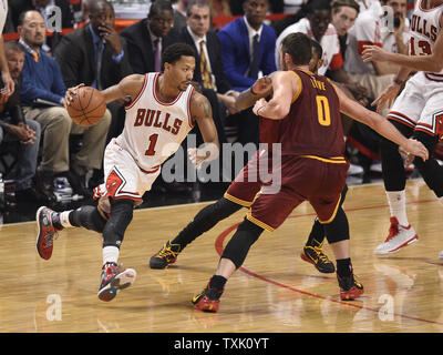 Chicago Bulls guard Derrick Rose (L) drives by Cleveland Cavaliers forward Kevin Love during the second quarter at the United Center in Chicago on October 31, 2014. The Cavaliers defeated the Bulls 114-108 in overtime.     UPI/Brian Kersey Stock Photo