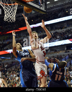 Chicago Bulls forward Mike Dunleavy (C) drives the the basket as Dallas Mavericks forward Brandan Wright (L) and guard Monta Ellis defend during the third quarter at the United Center on December 2, 2014 in Chicago. The Mavericks defeated the Bulls 132-129 in double overtime.     UPI/Brian Kersey Stock Photo