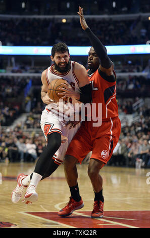 Chicago Bulls forward Nikola Mirotic (L) drives as Atlanta Hawks forward Paul Millsap defends during the second quarter at the United Center in Chicago on April 15, 2015.    Photo by Brian Kersey/UPI Stock Photo
