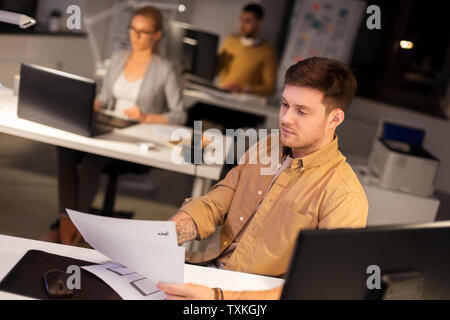 designer or software developer at night office Stock Photo