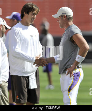 Brett Favre (L) shakes hands with Cleveland Browns player Corey Williams as  he walks onto the field after being traded to the New York Jets from the  Green Bay Packers during a