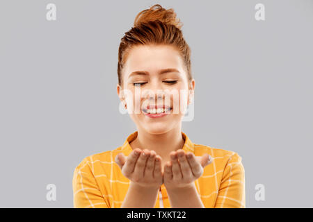 happy red haired teenage girl holding empty hands Stock Photo