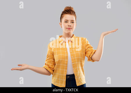 red haired teenage girl holding empty hands Stock Photo