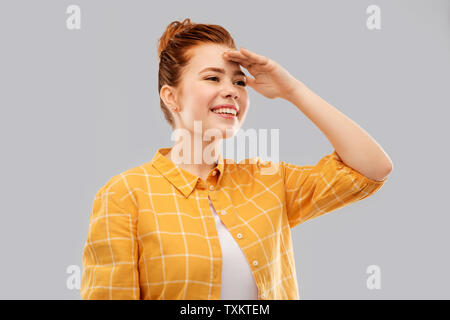 smiling red haired teenage girl looking far away Stock Photo