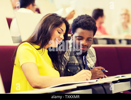 group of students with notebooks in lecture hall Stock Photo