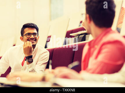 group of students with notebooks in lecture hall Stock Photo