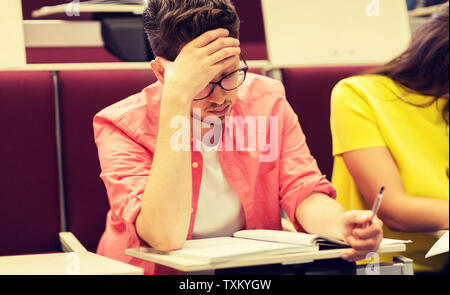 group of students with notebooks in lecture hall Stock Photo