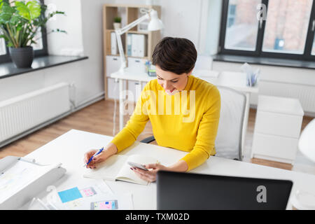 smiling ui designer using smartphone at office Stock Photo