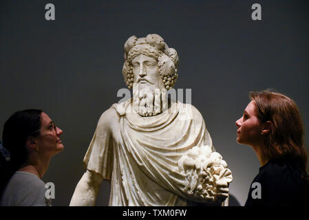 London, UK.  25 June 2019. Staff members view 'Silvanus' a 1st century AD Roman marble scuplture, from Galerie Chenel at a preview of Masterpiece London 2019, the world's leading cross-collecting art fair held in the grounds of the Royal Hospital Chelsea.  The fair brings together 157 international exhibitors presenting works from antiquity to the present day and runs 27 June to 3 July 2019. Credit: Stephen Chung / Alamy Live News Stock Photo