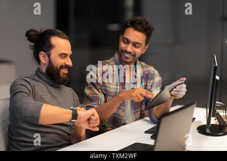 creative team with tablet pc works at night office Stock Photo